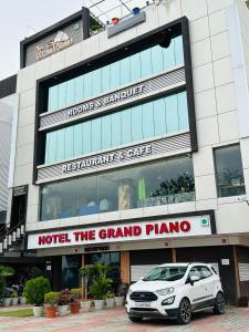 PātanHotel The Grand Piano - Best Business Hotel in Patan的停在大楼前的白色汽车