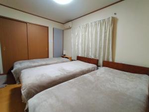 札幌At Home N23的一间卧室设有两张床和窗户。