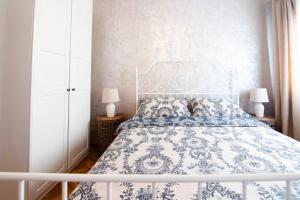 锡尼Apartman Karla的一间卧室配有一张带两盏灯的蓝色和白色的床。