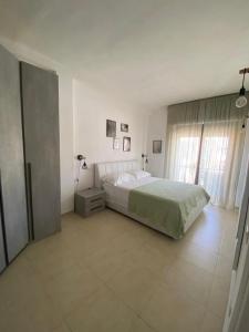夸尔图-圣埃莱娜Civico 107的白色的卧室设有床和窗户