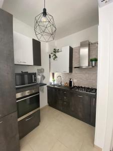 夸尔图-圣埃莱娜Civico 107的厨房配有黑白橱柜和微波炉