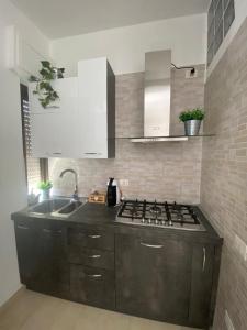 夸尔图-圣埃莱娜Civico 107的厨房配有水槽和炉灶 顶部烤箱