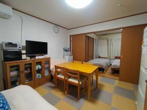 札幌At Home N23的一间带桌子和电视的房间以及一间卧室