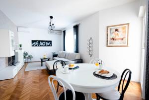 锡尼Apartman Karla的白色的客厅配有白色的桌子和椅子