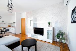 锡尼Apartman Karla的一间带电视和白色墙壁的客厅