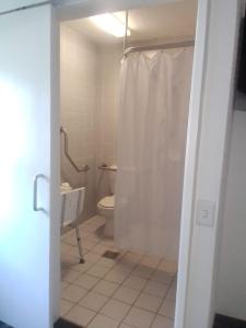 金伯利SUN1 Kimberley的浴室设有卫生间和带窗帘的淋浴。