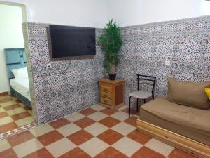 马拉喀什Appartement Relax Marrakech, شقة عائلية بمراكش متوفرة على غرفتين的客厅设有瓷砖墙壁上的电视