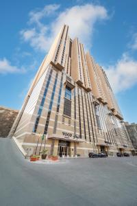 麦加voco Makkah an IHG Hotel的一座高大的建筑,带有圆锥形