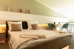 巴亚马雷VIVO Loft Short Stay的一间卧室配有一张大床和两张绿色椅子