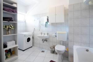 锡尼Apartman Karla的白色的浴室设有卫生间和水槽。