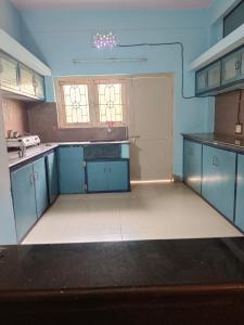 维沙卡帕特南Feel Like Home Rkbeach的厨房配有蓝色橱柜和白色地板