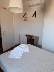 马里纳迪马萨B&B Il Viaggiatore的一间卧室配有一张带两条白色毛巾的床