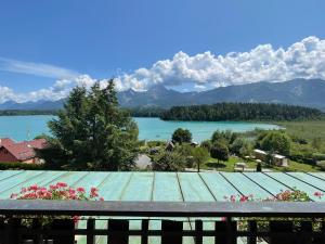 法克湖畔杜罗博拉赫雷斯曼湖滨酒店的阳台享有湖泊和山脉的景致。