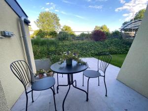 让布卢Le Relais de la Posterie的庭院里设有两把椅子和一张带鲜花的桌子