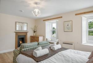 波特里斯The Boy's Cottage的一间卧室配有一张床、一张沙发和一个壁炉