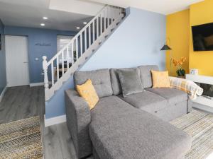 兰迪德诺Jasmine Villa的带沙发和楼梯的客厅