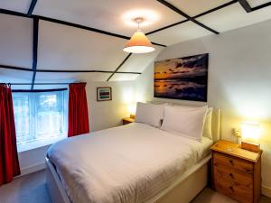 布里奇沃特Pass the Keys Cosy Cottage with Fireplace的一间卧室设有一张大床和一个窗户。