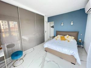 尼斯Beach front, Superbe appartement pour 4 personnes的一间卧室设有一张大床和蓝色的墙壁