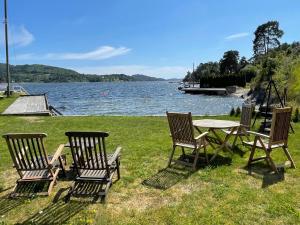 波什格伦Leilighet ved sjøen med strand的湖畔野餐桌和四把椅子