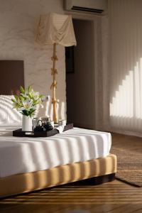 EspollaHotel Canaleta Heras的一张白色的床,上面有花瓶