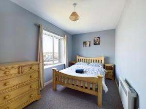 沃特福德Holiday Apartment Iris的一间卧室设有一张木床和一个窗户。