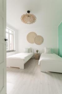 金洛伊Vakantiewoning 't Hovenshuis的白色的客房设有两张床和吊灯。
