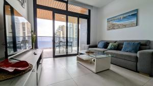 贝尼多姆SUNSET WAVES sea view apartments的客厅配有沙发和桌子