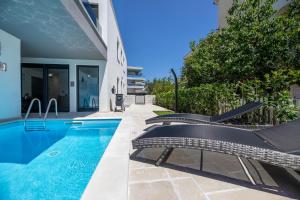克尔克Luxury Villa Adria Apartments的一座房子旁带两把椅子的游泳池