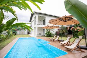 关丹Kontor Mansion - 3 mins to Teluk Chempedak Beach & Private Pool的房屋旁的游泳池配有椅子和遮阳伞