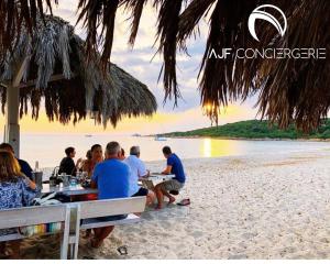 阿雅克修Appart'hotel grande terrasse vue mer的一群坐在海滩桌子上的人