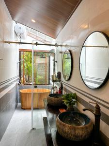 木州县Gobies Garden的一间带两个盥洗盆和大镜子的浴室