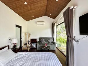 木州县Gobies Garden的一间卧室配有一张床、一张沙发和一台电视。