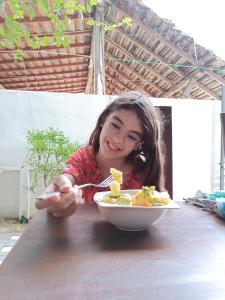 阿鲁甘湾The Amora的坐在桌子旁吃一碗食物的女孩