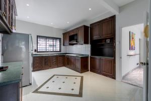 关丹Kontor Mansion - 3 mins to Teluk Chempedak Beach & Private Pool的厨房配有木制橱柜和瓷砖地板。