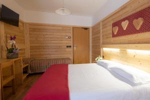 佩利扎诺科瓦酒店的卧室配有一张白色大床和一张书桌
