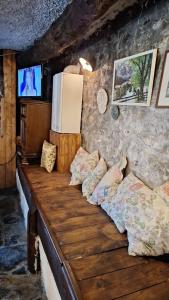 VaranoLA VECCHIA STALLA的配有电视的客房内的一张木沙发