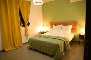 MatouryLa Palmeraie Lodge Terrasse & Piscine et Jacuzzi的一间卧室配有床和黄色窗帘