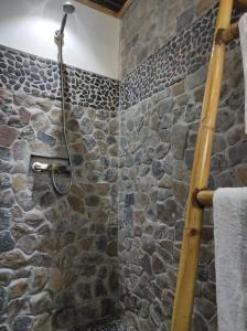 Nosy KombaVilla Ilo Komba的浴室设有石墙和石头淋浴。