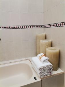 圣克里斯托瓦尔-德拉斯卡萨斯Posada Real de Chiapas的带浴缸、两把蜡烛和毛巾的浴室。