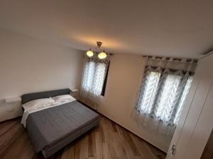 多尔切阿夸Il rifugio dei Doria的一间卧室设有一张床和两个窗户。