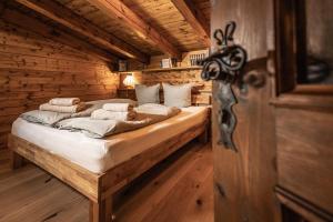 巴德伊舍Alpin-Chalet in Alleinlage in Bad Ischl - Wald, Natur, Kamin & Sauna的小木屋内一间卧室,配有一张床