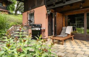 巴德伊舍Alpin-Chalet in Alleinlage in Bad Ischl - Wald, Natur, Kamin & Sauna的一个带椅子和炉灶的户外庭院