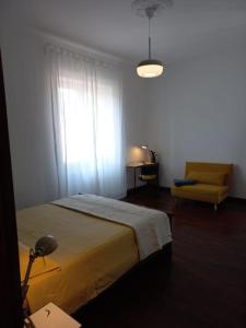 萨莱诺Giulia Town House tra città e mare的卧室配有床、椅子和窗户。