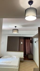 VrysesEmerald Suites的一间卧室设有一张床,天花板上设有两盏灯。