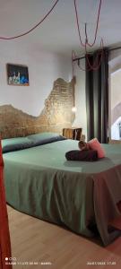 莱里达La Impronta Relax的一间卧室设有一张绿色的石墙床。