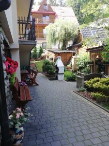 扎科帕内Willa Marianna的院子中一条有长椅和鲜花的走道
