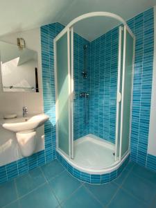 科希策Chata Jahodná的蓝色瓷砖浴室配有淋浴和盥洗盆
