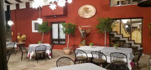 圣克里斯托瓦尔-德拉斯卡萨斯Posada Real de Chiapas的一间带桌椅和红色墙壁的餐厅