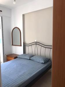 阿波罗Apollon Sunrise的一间卧室配有一张带蓝色毯子和镜子的床