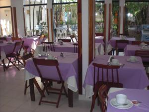 亚松森帕尔马斯德索尔酒店的一间用餐室,配有紫色的桌子和椅子